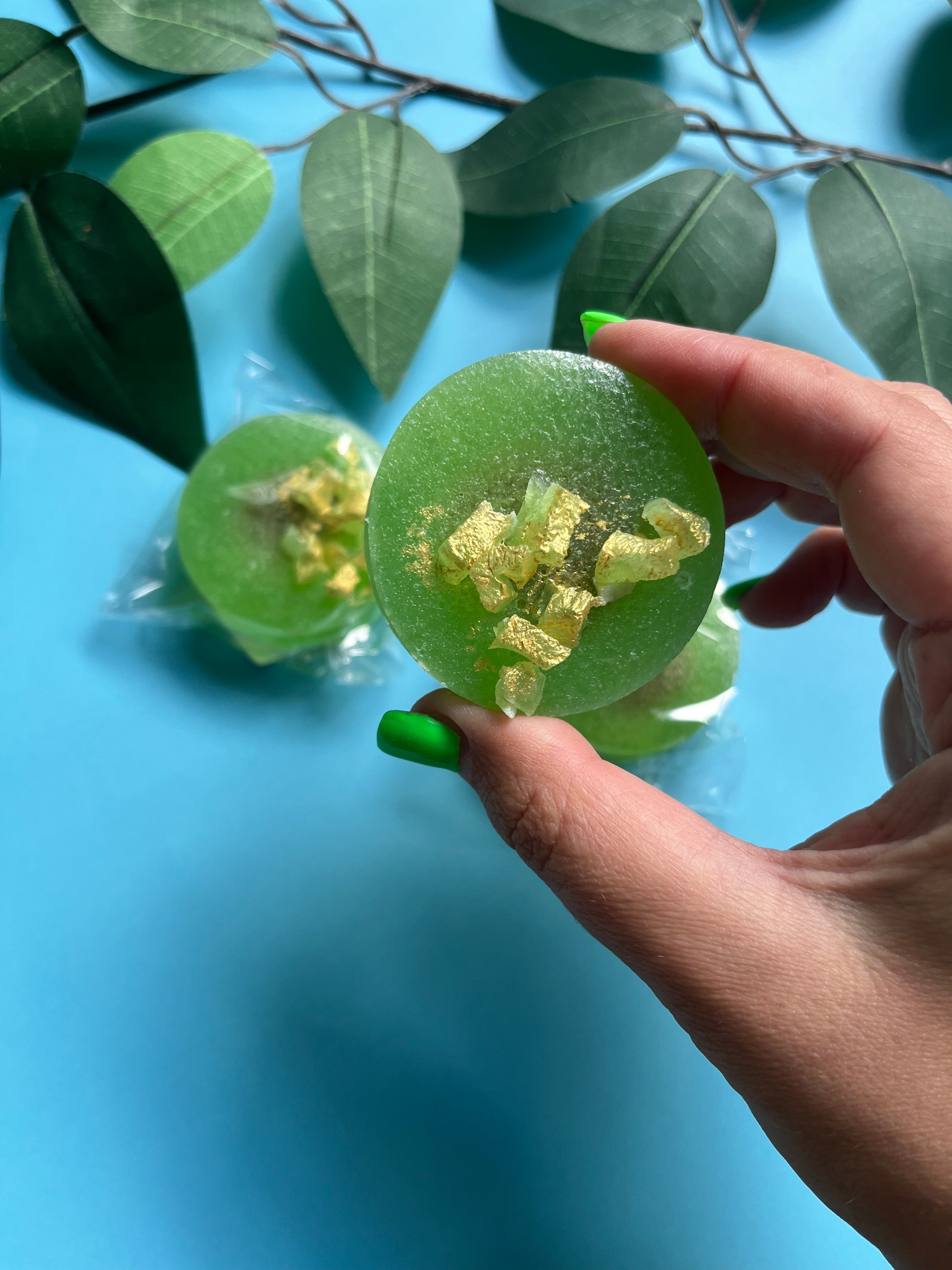 Top-down view of several bright green caramel-filled kohakutou pieces on a blue background