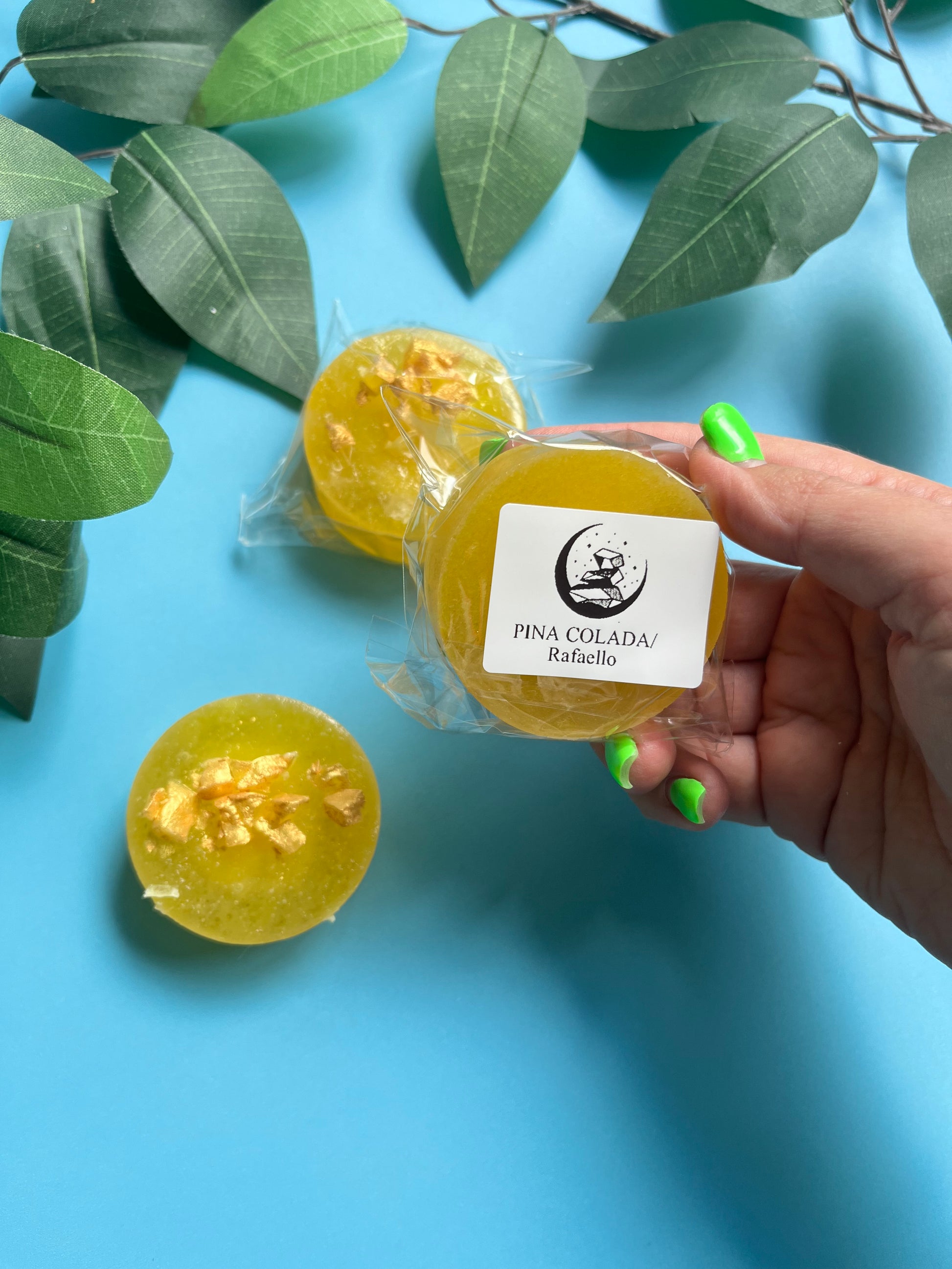 Hand holding glossy golden candy to show shine and color details