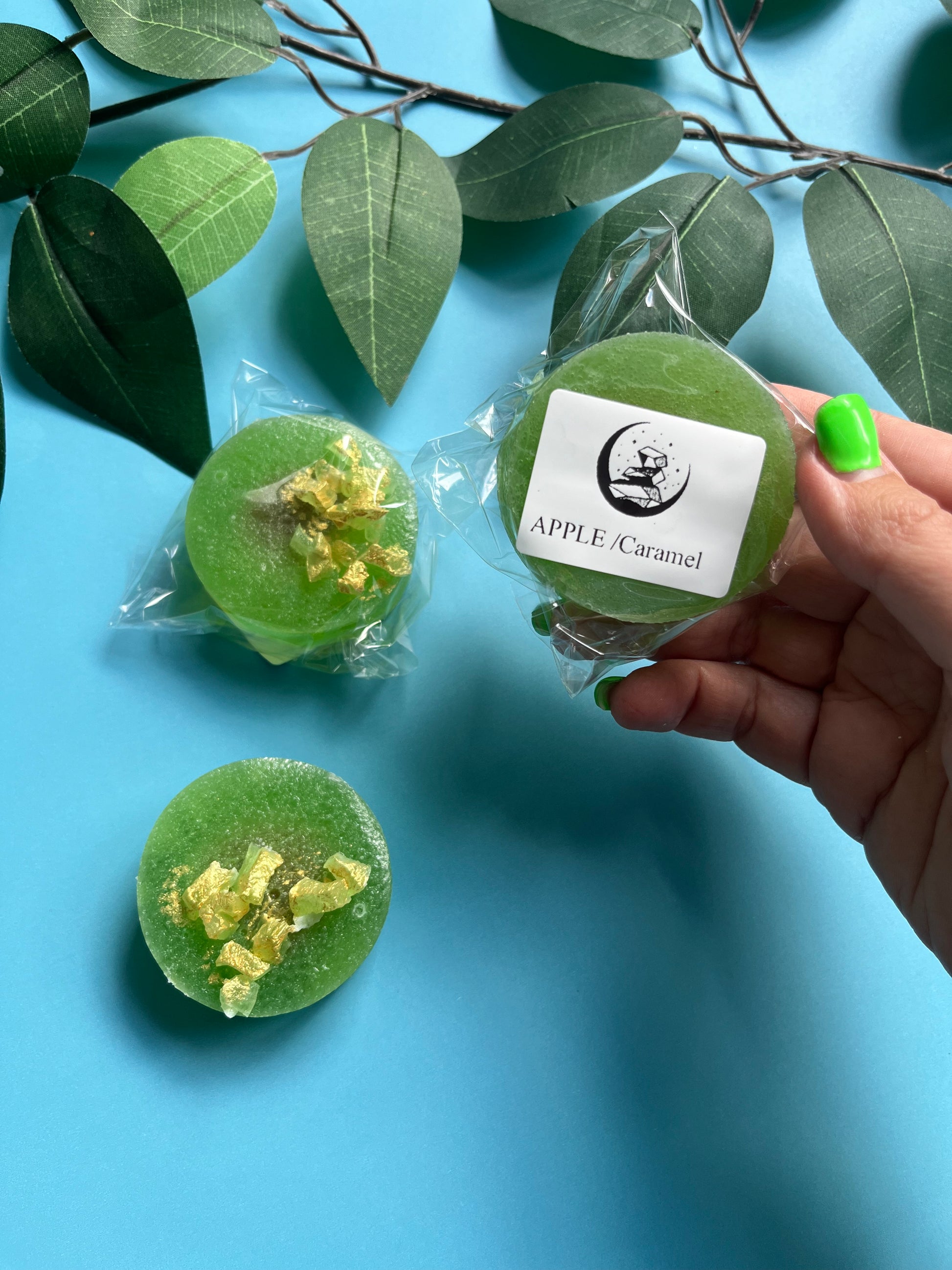 Green apple caramel gems laid out with shadows, showing glossy and sparkly surface