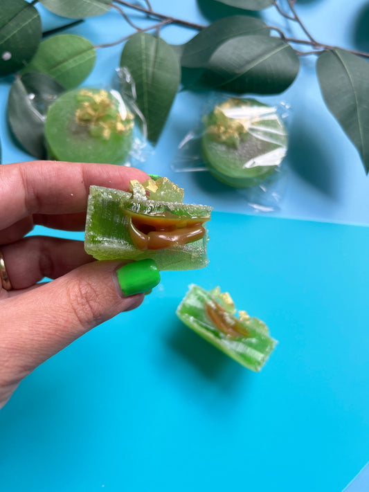 Close-up of sliced apple green crystal candy showing soft caramel filling inside
