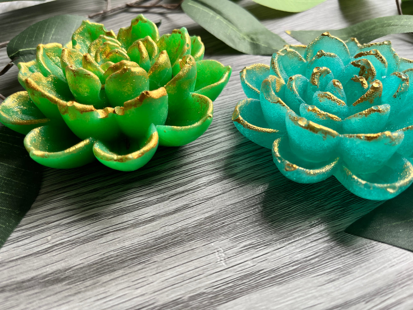 Handmade lotus flower candy in vibrant green and teal, with a crunchy sugar shell