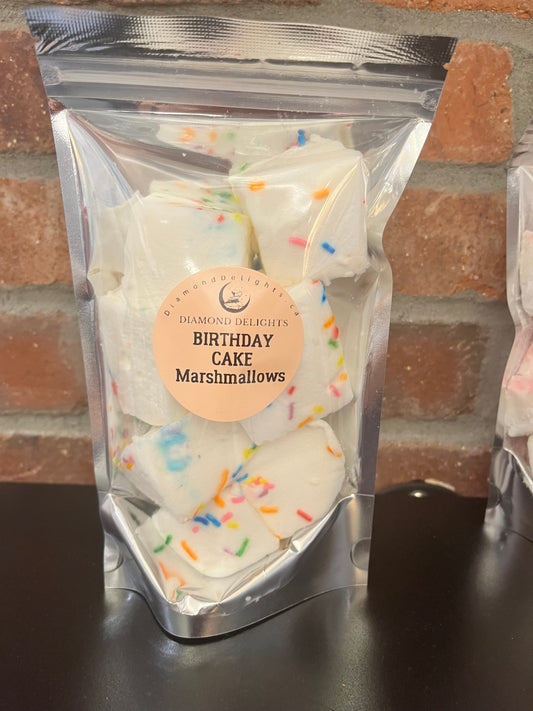 Bag of fluffy birthday cake marshmallows topped with rainbow sprinkles in a clear resealable pouch.