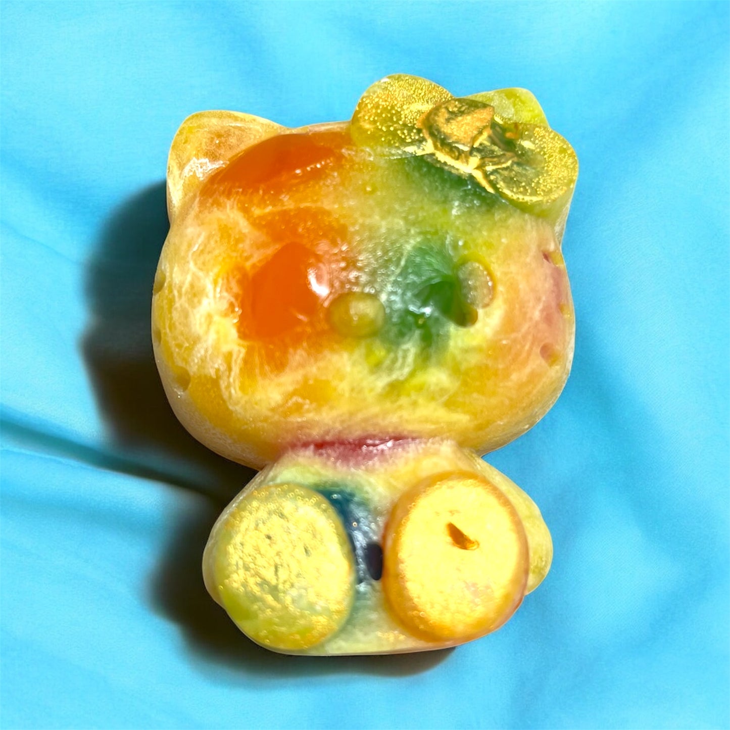 Colorful cat-shaped gummy candy on a blue background