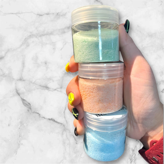 Hand holding Sparkle Sour Candy Dip jar with layered edible glitter sugar
