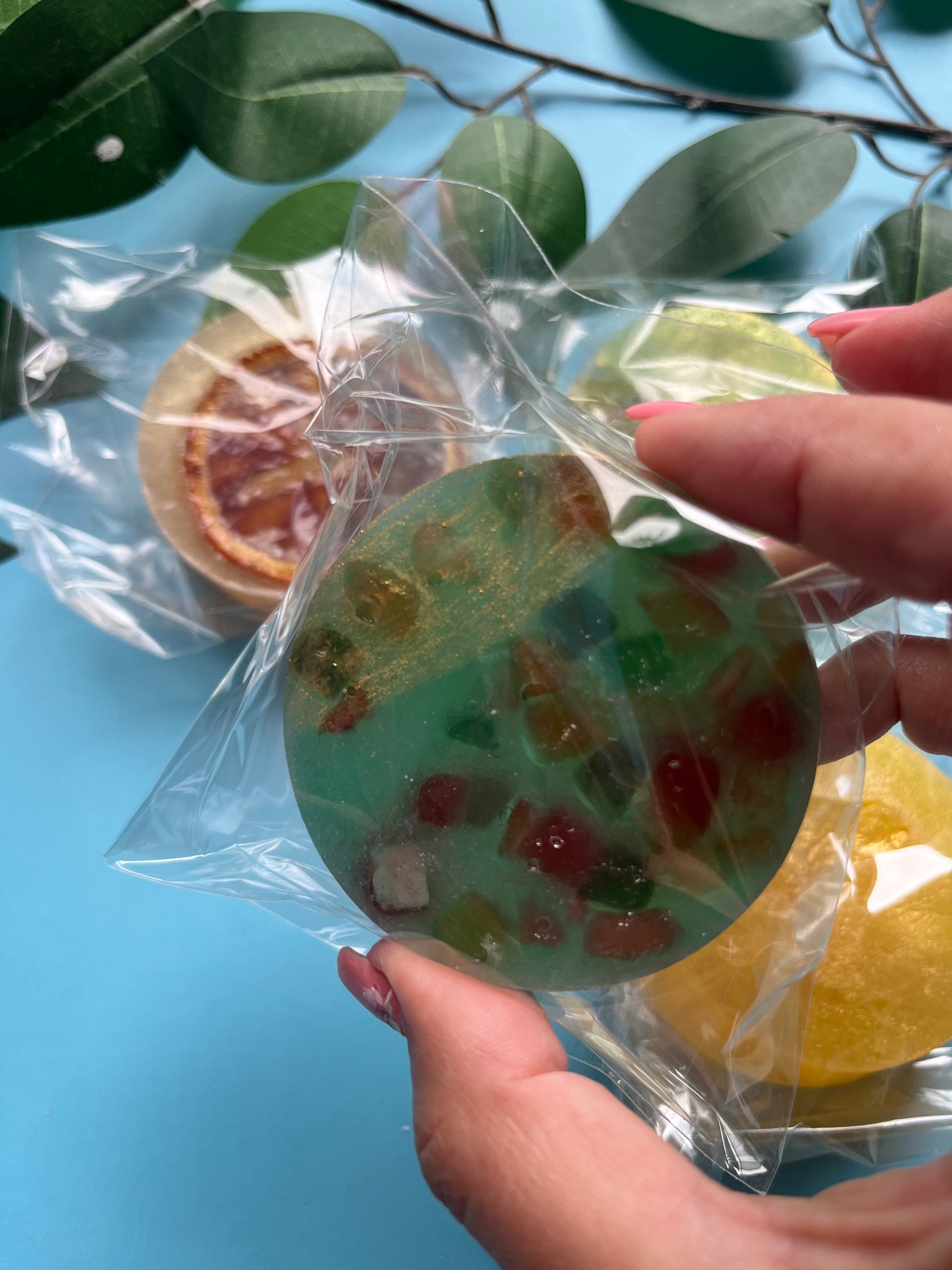 Blue raspberry crystal candy with multicolored dried fruit chunks embedded inside, giving a stained glass effect.