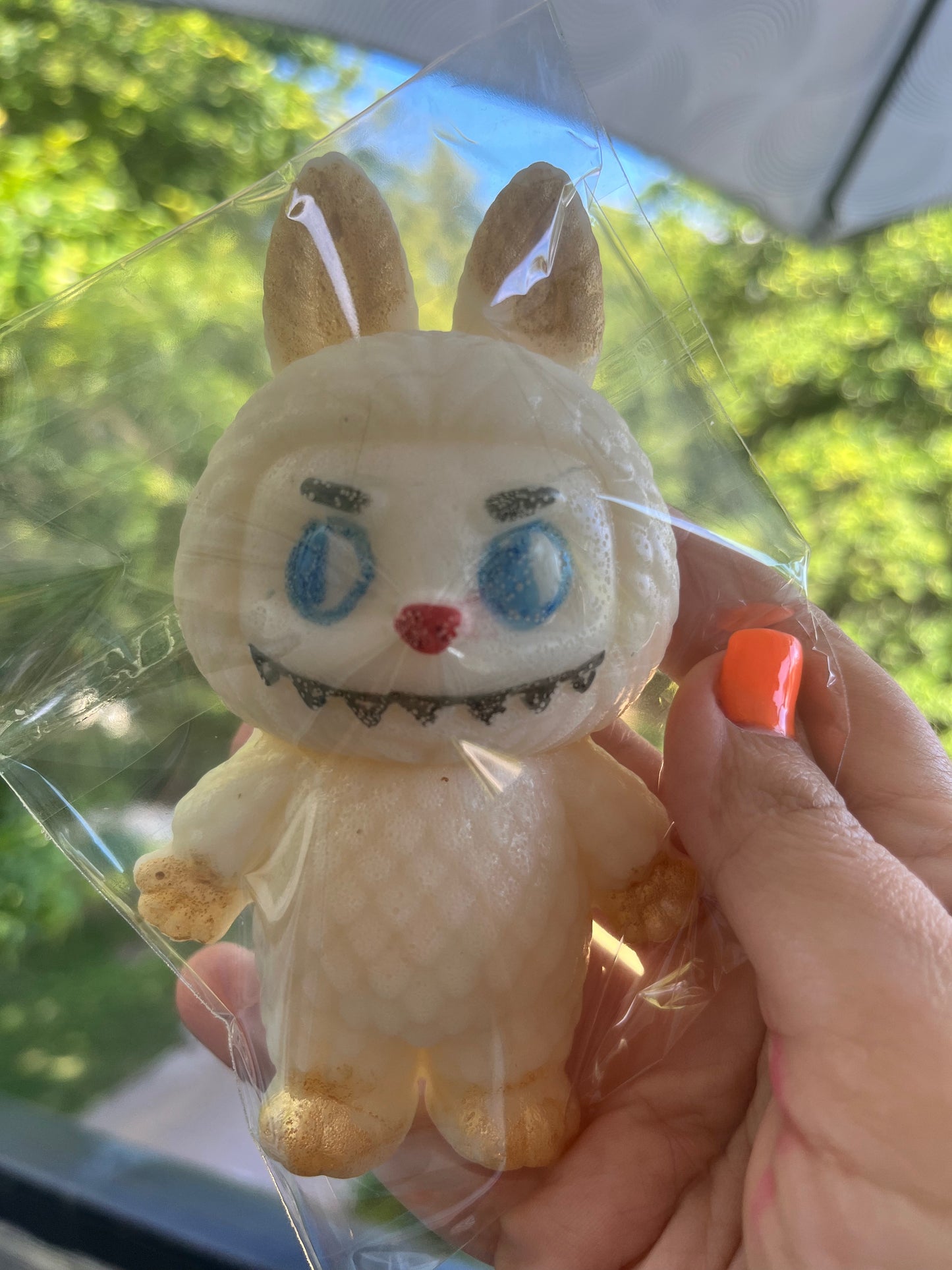 Side view of Labubu-shaped edible candy figure, highlighting golden shimmer on ears and feet
