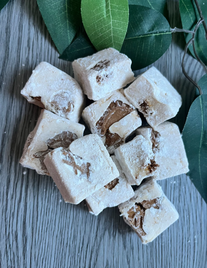 Biscoff-flavored marshmallows, packed with cookie chunks, on wood background.