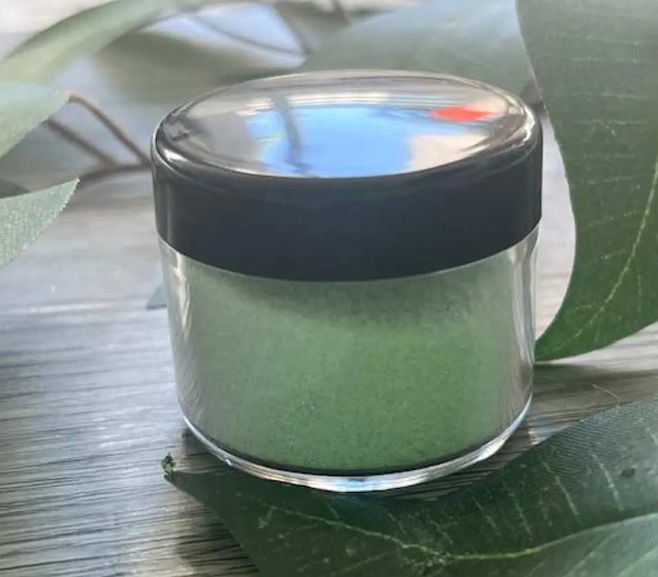 Top view of bright green dip powder in jar