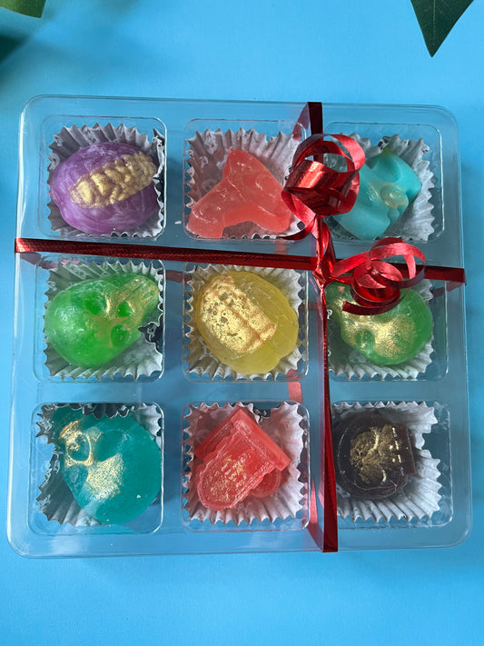 Assorted colorful candies in a clear plastic container with a red ribbon on a light blue background