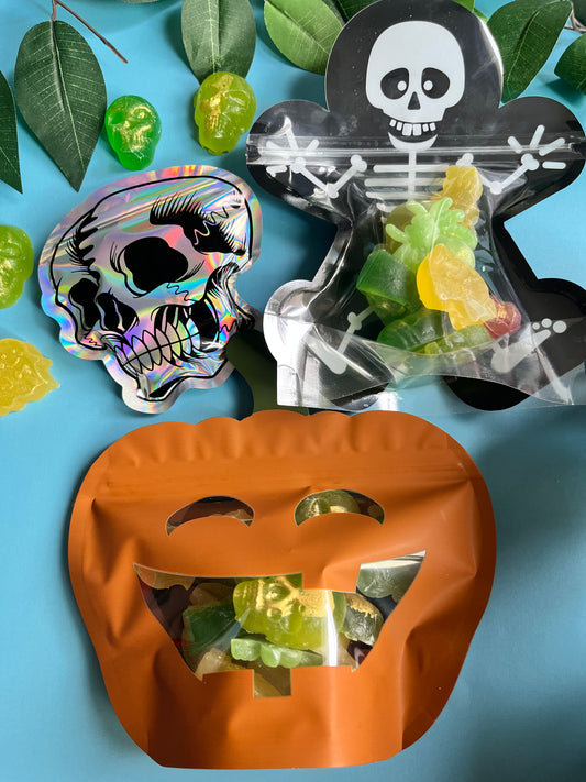 Halloween-themed candy containers with skull designs on a blue background