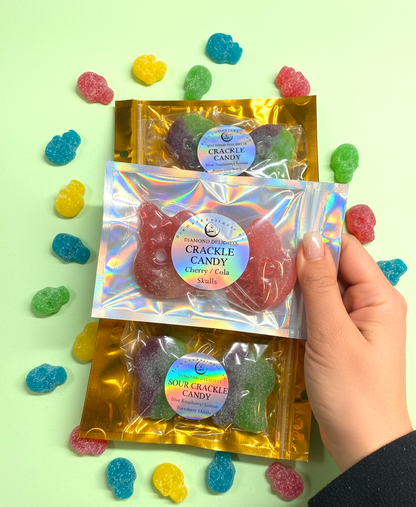 Hand holding a package of crinkle candy with colorful gummy bears on a light green background