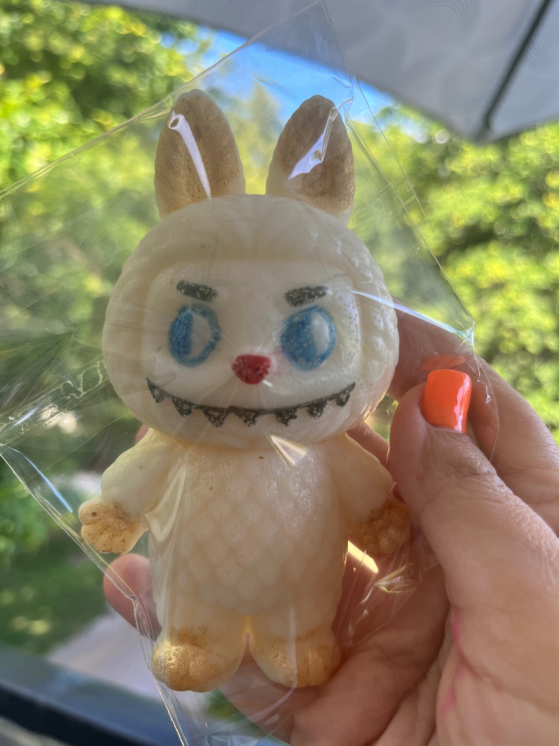 Side view of Labubu-shaped edible candy figure, highlighting golden shimmer on ears and feet