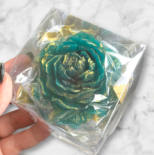 A close up of a teal candy flower in a box